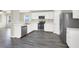 The bright kitchen features white cabinets, stainless steel appliances, and gray wood-look flooring at 5783 Sol Vista Ave, Las Vegas, NV 89122