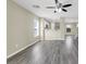 The living room has gray wood floors and neutral walls with an open view to the kitchen with white cabinets at 5783 Sol Vista Ave, Las Vegas, NV 89122