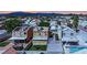 An aerial view shows houses with tile roofs in a desert community near mountains with pools and green yards at 5845 Killala Ct, Las Vegas, NV 89110