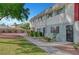 Charming townhome featuring a well-maintained lawn and quaint landscaping at 609 Greenbriar Townhouse Way, Las Vegas, NV 89121