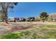Open lawn area and landscaping in front of condos, accentuated by mature trees and blue skies at 609 Greenbriar Townhouse Way, Las Vegas, NV 89121