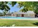 Relaxing community pool surrounded by green grass, trees and fence at 609 Greenbriar Townhouse Way, Las Vegas, NV 89121