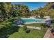 Community pool, with surrounding green spaces, landscaping and picnic areas at 609 Greenbriar Townhouse Way, Las Vegas, NV 89121