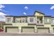 View of a row of townhomes, each with private garages, balconies, and complementary color schemes at 6437 Wide Sky St, Las Vegas, NV 89166