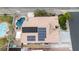 Aerial view of a home with a tile roof, solar panels, lush landscaping, and a sparkling pool and spa at 6493 Yellow Bells Ct, Las Vegas, NV 89131