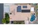 Aerial view of a home with a tile roof, solar panels, lush landscaping, and a sparkling pool and spa at 6493 Yellow Bells Ct, Las Vegas, NV 89131