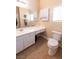 Bright bathroom featuring a single sink vanity, white cabinetry, and a toilet with a beige colored tile floor at 6493 Yellow Bells Ct, Las Vegas, NV 89131