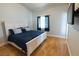 Bedroom featuring a bed with a white frame, a blue comforter and light hardwood flooring at 6493 Yellow Bells Ct, Las Vegas, NV 89131