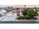Charming single-story home featuring well-maintained landscaping, a three-car garage, and a beautiful sunset backdrop at 6493 Yellow Bells Ct, Las Vegas, NV 89131