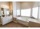 A luxurious main bathroom featuring double sinks, a soaking tub, and ample natural light at 6493 Yellow Bells Ct, Las Vegas, NV 89131