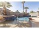 Inviting pool and spa with blue tile accents, surrounded by lush palm trees for a tropical oasis at 6493 Yellow Bells Ct, Las Vegas, NV 89131
