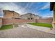Landscaped backyard featuring synthetic grass, a stone fire pit, desert landscaping, and a patio with pavers at 7109 Red Gulch St, North Las Vegas, NV 89084