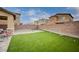 Lush backyard features artificial turf, a fire pit, and block wall fencing for privacy and enjoyment at 7109 Red Gulch St, North Las Vegas, NV 89084