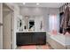 Chic bathroom with double vanity, tub-shower combo, and heart-patterned accent wall at 7109 Red Gulch St, North Las Vegas, NV 89084