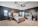 Well-lit bedroom with dark accent walls, ceiling fan, and carpeted floor at 7109 Red Gulch St, North Las Vegas, NV 89084