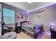 This cozy bedroom has a comfortable bed, gray walls, and fun decor at 7109 Red Gulch St, North Las Vegas, NV 89084