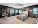 Stylish bedroom with dark accent wall, neutral carpet, ceiling fan, and natural light at 7109 Red Gulch St, North Las Vegas, NV 89084