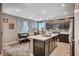 Modern kitchen with a center island, dark cabinetry, stainless steel appliances, and an adjacent dining area at 7109 Red Gulch St, North Las Vegas, NV 89084