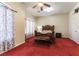 This cozy bedroom features a carved wood bed frame, bench, ceiling fan and plush red carpeting at 7549 Evening Falls Dr Dr, Las Vegas, NV 89131