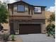Inviting home featuring a two-car garage, classic shutters, and attractive desert landscaping at 8412 Sycamore Creek St, Las Vegas, NV 89113