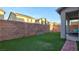 Relaxing backyard featuring artificial turf, privacy walls, and a covered patio with outdoor seating area at 8532 Caddy Corner St, Las Vegas, NV 89139