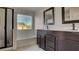 Bright bathroom features a soaking tub, black fixtures, and a double sink vanity at 8532 Caddy Corner St, Las Vegas, NV 89139