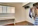 Bright bedroom features a closet, wood-look floors, and white desk by a window at 8532 Caddy Corner St, Las Vegas, NV 89139