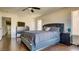 Large bedroom with an upholstered bed, dark wood-look floors, and a ceiling fan at 8532 Caddy Corner St, Las Vegas, NV 89139