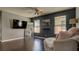 Modern living room with dark gray accent wall, hardwood floors, and an oversized comfy chair at 8532 Caddy Corner St, Las Vegas, NV 89139