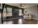 Modern living room with dark walls, hardwood floors, a ceiling fan, and large comfy chair at 8532 Caddy Corner St, Las Vegas, NV 89139