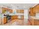 Updated kitchen featuring wooden cabinets, stainless steel appliances, modern backsplash, and tile floors at 8600 Soneto Ln, Las Vegas, NV 89117