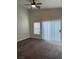 Carpeted bedroom with neutral walls, ceiling fan, sliding door, and lots of natural light at 9078 Camp Light Ave # 102, Las Vegas, NV 89149