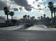 Gated community entrance with mature palm trees and mountain views in the distance at 9078 Camp Light Ave # 102, Las Vegas, NV 89149