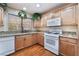 Well-lit kitchen features oak cabinets, granite counters and wood flooring for modern cooking at 9305 Quail Ridge Dr, Las Vegas, NV 89134