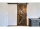 Rustic-style barn door with iron track and hardware adds a unique touch to this modern home at 10650 Sariah Skye Ave, Las Vegas, NV 89166