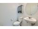 This half bathroom offers a pedestal sink, white toilet, and decorative mirror at 10650 Sariah Skye Ave, Las Vegas, NV 89166
