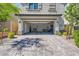Two-car garage with a wide driveway and exterior landscaping at 10650 Sariah Skye Ave, Las Vegas, NV 89166
