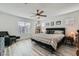 Bright main bedroom with a ceiling fan, wood-look flooring, and large windows at 10650 Sariah Skye Ave, Las Vegas, NV 89166