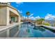 Image shows a large backyard pool with water features and green landscape at 19 Hilltop Crest St, Henderson, NV 89011
