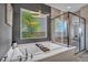 This bathroom has a soaking tub with a modern chandelier and a separate glass shower at 19 Hilltop Crest St, Henderson, NV 89011