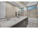 Bright bathroom featuring double sinks, a large mirror, and a shower-tub combination with decorative tiling at 19 Hilltop Crest St, Henderson, NV 89011