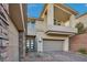 Contemporary home with stone accents, a three-car garage, and a private balcony at 19 Hilltop Crest St, Henderson, NV 89011