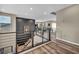 Bright hallway with modern railing and hardwood floors leads to living area; artwork on the wall adds character at 19 Hilltop Crest St, Henderson, NV 89011