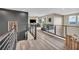 Hallway with wood floors, black accent wall, and railing overlooking home office space at 19 Hilltop Crest St, Henderson, NV 89011