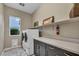Bright laundry room with white washer and dryer, overhead shelf and gray cabinets at 19 Hilltop Crest St, Henderson, NV 89011