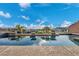 Luxurious pool area showcasing in-water lounge seating, lush landscaping, and sunny skies at 19 Hilltop Crest St, Henderson, NV 89011