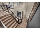 Modern staircase with wood steps, metal railings, and black accent wall with artwork at 19 Hilltop Crest St, Henderson, NV 89011
