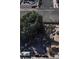 An aerial view of a home with a large tree providing shade, surrounded by cars and stored items on a gravel lot at 2510 Sunrise St, Las Vegas, NV 89101