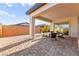 Spacious back patio with pavers, covered area with seating, and block wall with decorative stone accents at 31 Autumn Palm Ave, Henderson, NV 89011