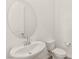 This bathroom features a white sink, toilet and round mirror at 31 Autumn Palm Ave, Henderson, NV 89011